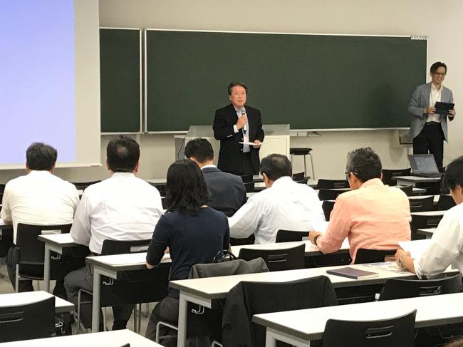 外部評価委員の皆様を前に趣旨説明をする日秋主任